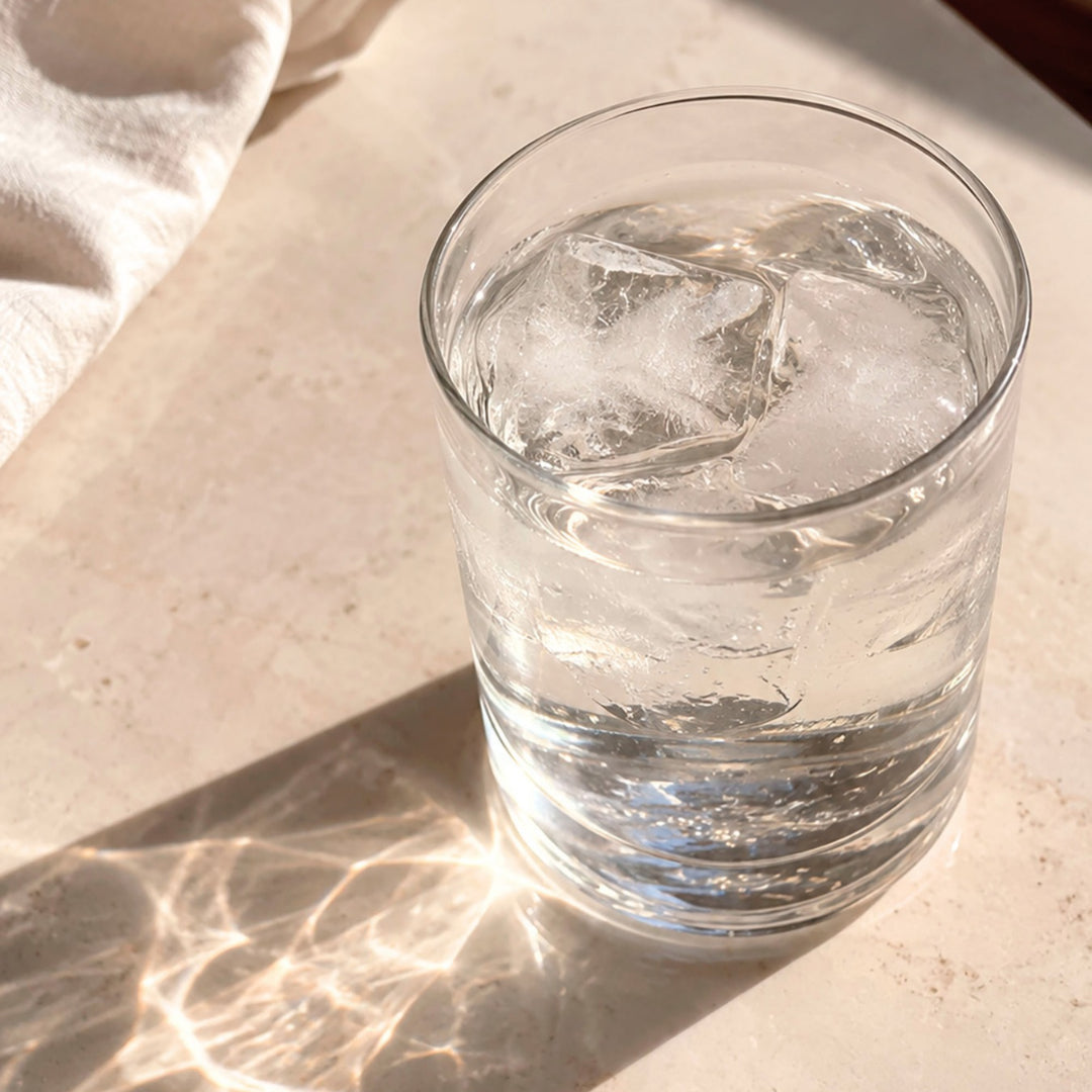 Et glass vann i naturlig lys for å illustrere hydrering